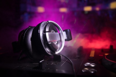 In selective focus of Pro dj controller.The DJ console deejay mixing desk at music party in nightclub with colored disco lights. Close up viewの写真素材