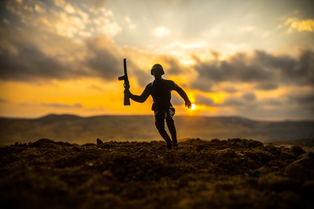 War Concept. Military silhouettes fighting scene on war fog sky background, World War Soldiers Silhouettes Below Cloudy Skyline at sunset. Soldier trying to escape from tankの写真素材