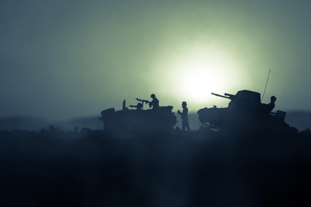War Concept. Military silhouettes fighting scene. World War German Tanks and soldiers silhouettes at sunset. Attack scene. Armored vehicles. Tanks battleの写真素材