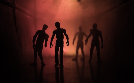 Creepy silhouette in the dark abandoned building. The zombie apocalypse concept or Dark corridor with silhouettes of spooky horror zombies standing with different poses.の写真素材