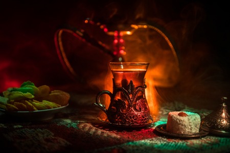 Hookah hot coals on shisha bowl making clouds of steam at Arabian interior. Oriental ornament on the...