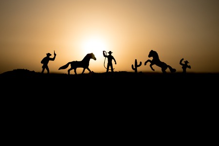 Cowboy concept. Silhouette of Cowboys at sunset time. Cowboys silhouettes on a hill with horses....