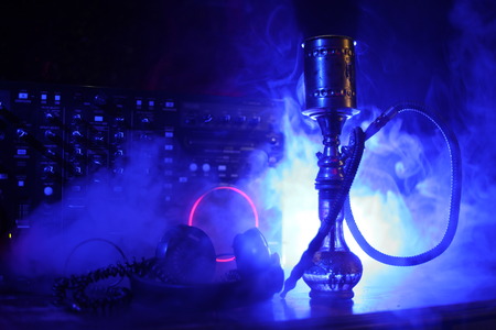Shisha party club concept. Dj mixer with on dark nightclub background with stylish oriental shisha....