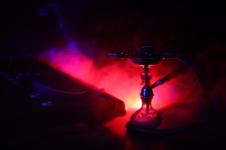 Shisha party club concept. Dj mixer with on dark nightclub background with stylish oriental shisha. Selective focusの写真素材