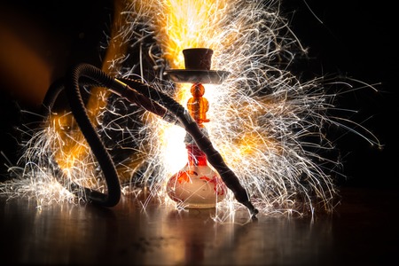 Hookah hot coals on shisha bowl making clouds of steam. Shisha explosion. Stylish oriental shisha in dark with fire. For Shisha advertisement. Burning shisha conceptの写真素材