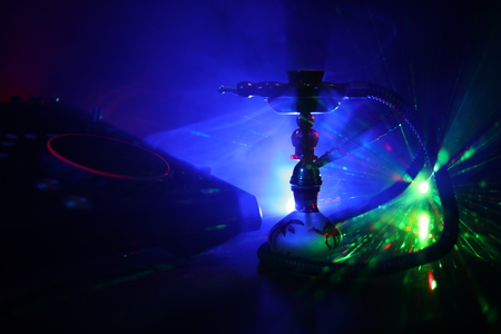 Shisha party club concept. Dj mixer with on dark nightclub background with stylish oriental shisha. Selective focusの写真素材