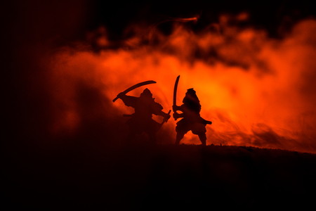 Silhouette of two samurais in duel. Picture with two samurais and sunset sky. Selective focusの写真素材