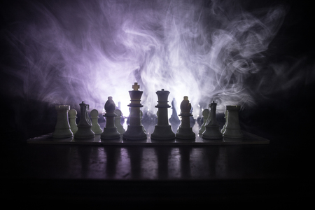 Chess board game concept of business ideas and competition or strategy ideas concept. Chess figures on a dark toned foggy background. Selective focusの写真素材