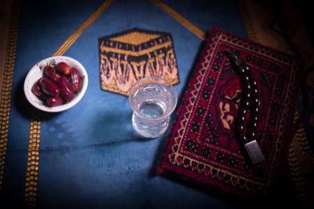 Water and dates. Iftar is the evening meal. View of decoration Ramadan Kareem holiday on carpet. Festive greeting card, invitation for Muslim holy month Ramadan Kareem. Selective focusの写真素材