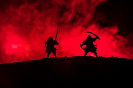 Silhouette of two samurais in duel. Picture with two samurais and sunset sky. Selective focusの写真素材