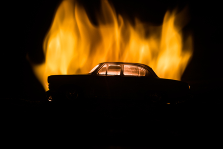 Silhouette of old vintage car in dark foggy toned background with glowing lights in low light. Selective focusの写真素材