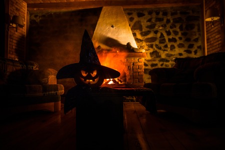 Creepy Halloween pumpkin near a fireplace. Fire on the background. Horror holiday conceptの写真素材