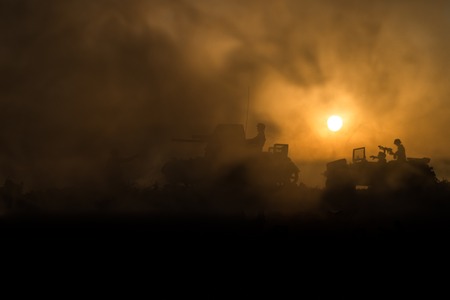War Concept. Military silhouettes fighting scene. World War German Tanks and soldiers silhouettes at sunset. Attack scene. Armored vehicles. Tanks battleの写真素材