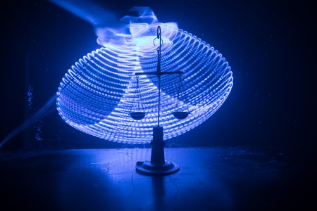 Justice scale with dark toned foggy background. Justice concept. Scale is symbol of justice. Selective focusの写真素材