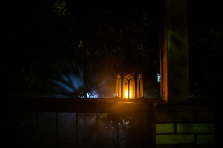 Retro style lantern at night. Beautiful colorful illuminated lamp at the balcony in the garden. Selective focusの写真素材