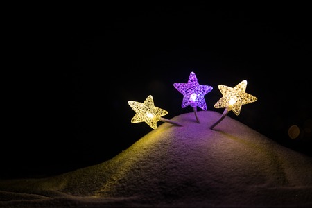 Abstract Winter background. Glowing stars in snow. New year Christmas concept
