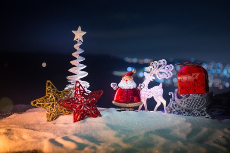 Christmas decorations. Fir tree standing on snow with beautiful holiday decorated background and...
