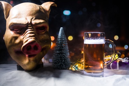 Mug of beer with Christmas decoration. Glass of light beer with foam in snow with creative New Year...
