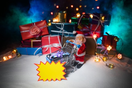 New year or Christmas holiday shopping concept. Store promotions. Santa Claus carrying trolley cart...