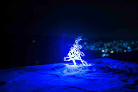 Christmas decorations. Fir tree standing on snow with beautiful holiday decorated background and traditional holiday attributes. Selective focus. Empty space for your textの写真素材