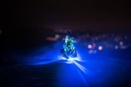 Christmas decorations. Fir tree standing on snow with beautiful holiday decorated background and traditional holiday attributes. Selective focus. Empty space for your textの写真素材