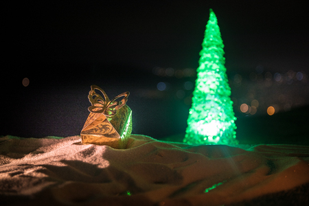 Christmas decorations. Fir tree standing on snow with beautiful holiday decorated background and traditional holiday attributes. Selective focus. Empty space for your textの写真素材