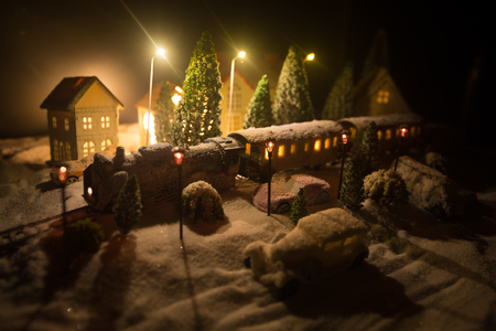 Miniature of winter scene with Christmas houses, train station, trees, covered in snow. Nights scene. New year or Christmas concept. Selective focusの写真素材