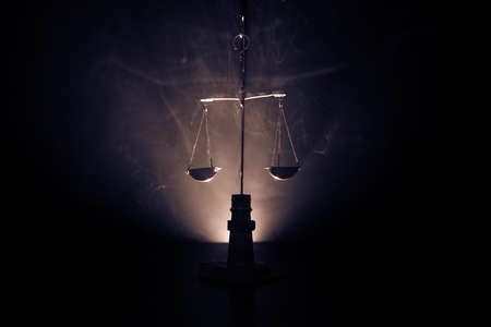 Justice scale with dark toned foggy background. Justice concept. Scale is symbol of justice. Selective focusの写真素材