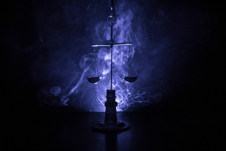 Justice scale with dark toned foggy background. Justice concept. Scale is symbol of justice. Selective focusの写真素材