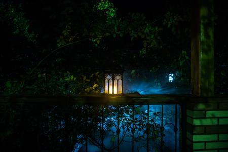 Retro style lantern at night. Beautiful colorful illuminated lamp at the balcony in the garden. Selective focusの写真素材