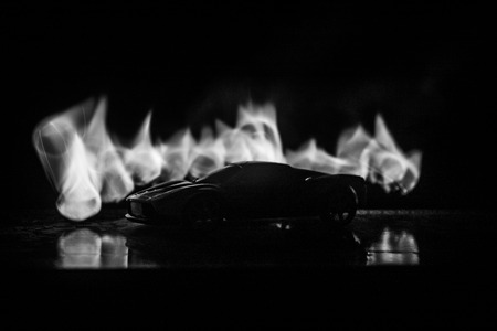 The car in the shadows with glowing lights in low light, or silhouette of sport car dark background. Selective focusの写真素材
