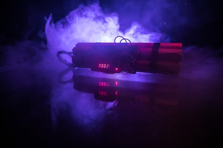 Image of a time bomb against dark background. Timer counting down to detonation illuminated in a shaft light shining through the darkness, conceptual imageの写真素材
