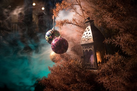 Bauble on tree. Christmas and New Year decoration on the pine tree branch with lights at the background at night outdoors. Concept of winter holidays. Selective focusの写真素材