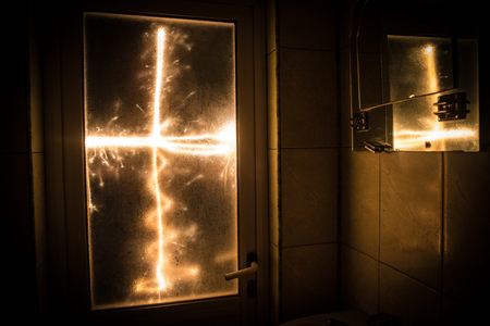 Horror silhouette of person in window. Scary halloween concept Blurred silhouette of witch in bathroom. Decorated with fireworksの写真素材