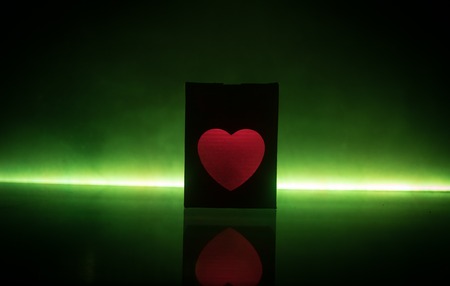 Dark table,Valentines day concept and love red shape heart with bokeh background, empty for text and placing products with copy space. Blurred glowing heart on a dark background with reflectionの写真素材