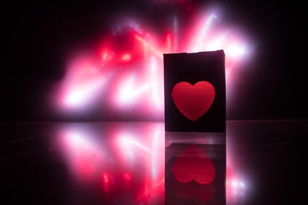 Dark table,Valentines day concept and love red shape heart with bokeh background, empty for text and placing products with copy space. Blurred glowing heart on a dark background with reflectionの写真素材