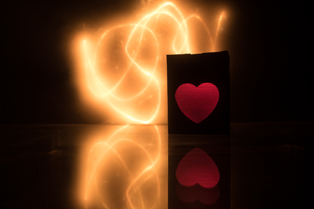 Dark table,Valentines day concept and love red shape heart with bokeh background, empty for text and placing products with copy space. Blurred glowing heart on a dark background with reflectionの写真素材