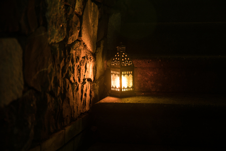 Beautiful colorful illuminated lamp in the garden in misty night. Retro style lantern at night outdoor. Selective focusの写真素材