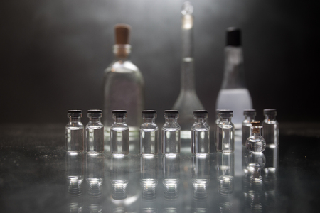 Pharmacy and chemistry theme. Test glass flask with solution in research laboratory. Science and medical background. Laboratory test tubes on dark toned background , science research equipment conceptの写真素材