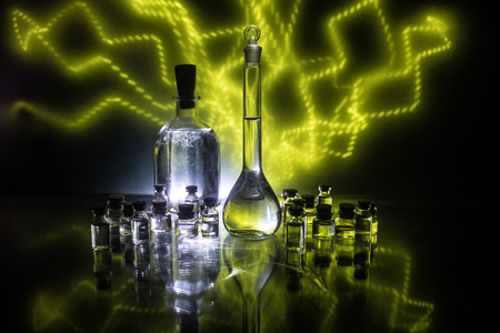 Pharmacy and chemistry theme. Test glass flask with solution in research laboratory. Science and medical background. Laboratory test tubes on dark toned background , science research equipment conceptの写真素材