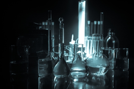 Pharmacy and chemistry theme. Test glass flask with solution in research laboratory. Science and medical background. Laboratory test tubes on dark toned background , science research equipment conceptの写真素材
