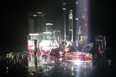 Pharmacy and chemistry theme. Test glass flask with solution in research laboratory. Science and medical background. Laboratory test tubes on dark toned background , science research equipment conceptの写真素材