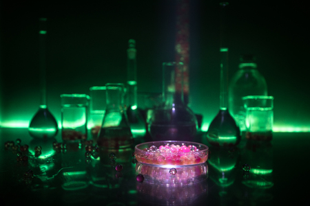 Pharmacy and chemistry theme. Test glass flask with solution in research laboratory. Science and medical background. Laboratory test tubes on dark toned background , science research equipment conceptの写真素材