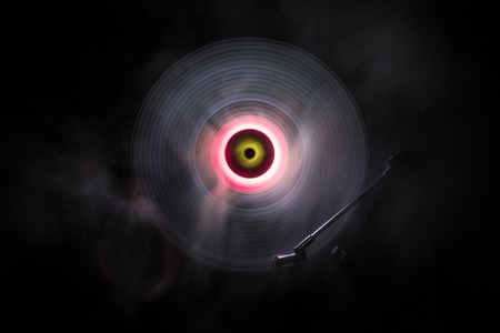 Music Dj concept. Trail of fire and smoke on vinyl record. Burning vinyl disk. Turntable vinyl record player on dark background. Selective focusの写真素材