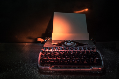 Old fashion typewritter on dark foggy background. Close up of vintage typewritter machine. Selective focusの写真素材