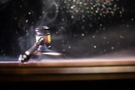 Law theme, mallet of the judge on wooden desk with Lady Justice Statue. Law gavel on dark foggy background with light. Selective focusの写真素材