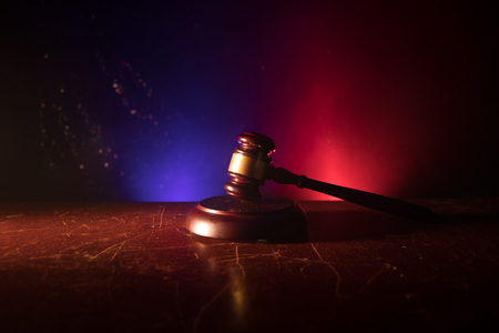 Law theme, mallet of the judge on wooden desk with Lady Justice Statue. Law gavel on dark foggy background with light. Selective focusの写真素材
