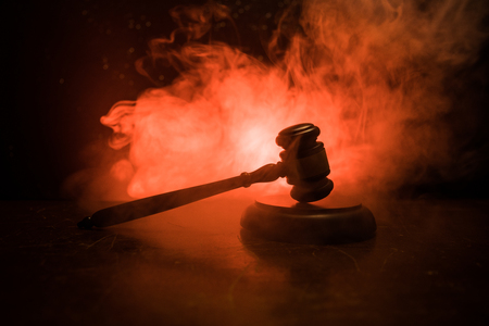 Law theme, mallet of the judge on wooden desk with Lady Justice Statue. Law gavel on dark foggy background with light. Selective focusの写真素材