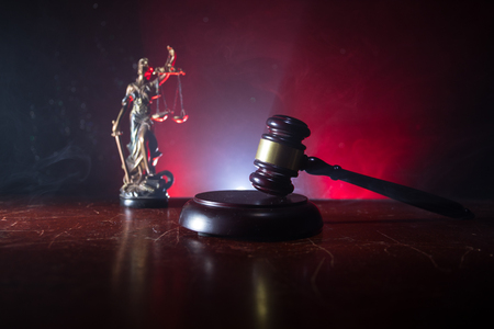 Law theme, mallet of the judge on wooden desk with Lady Justice Statue. Law gavel on dark foggy background with light. Selective focusの写真素材