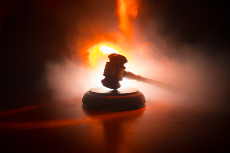Law theme, mallet of the judge on wooden desk with Lady Justice Statue. Law gavel on dark foggy background with light. Selective focusの写真素材